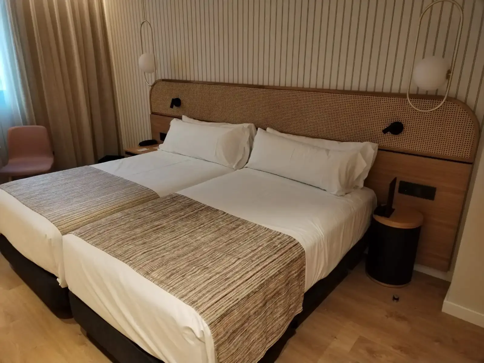 Dormitorio de hotel con cabecero de madera y ratán