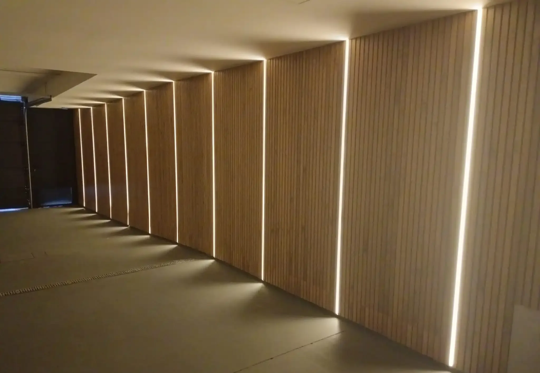 Pasillo revestido con lamas de madera e iluminación LED integrada